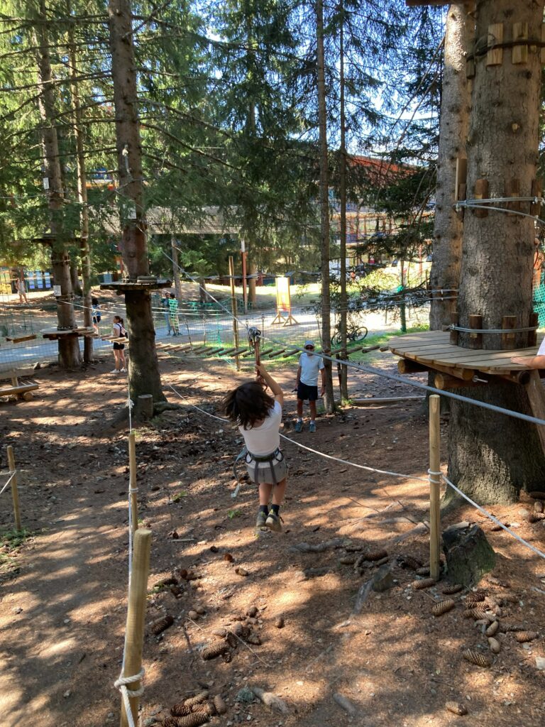 Enfant sur un atelier du parcours accrobranche entre les mélèzes