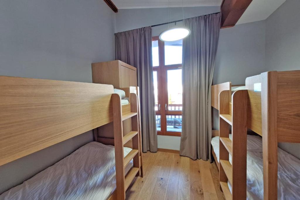 Chambre enfants avec lits superposés et fenêtre sur la montagne