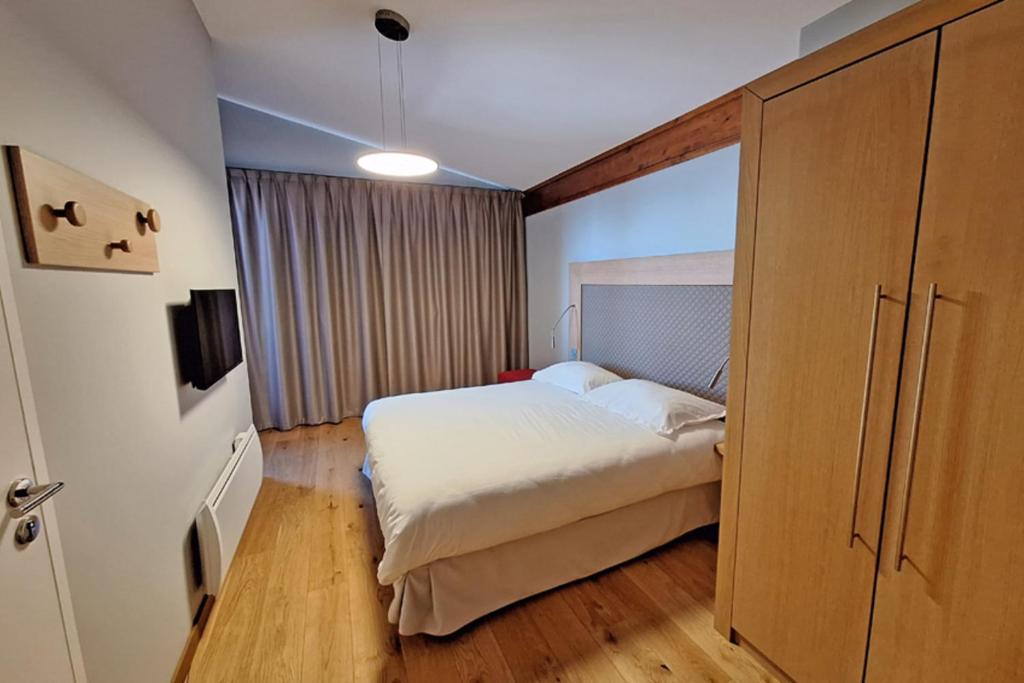 Chambre double avec lit deux places et grand placard en bois