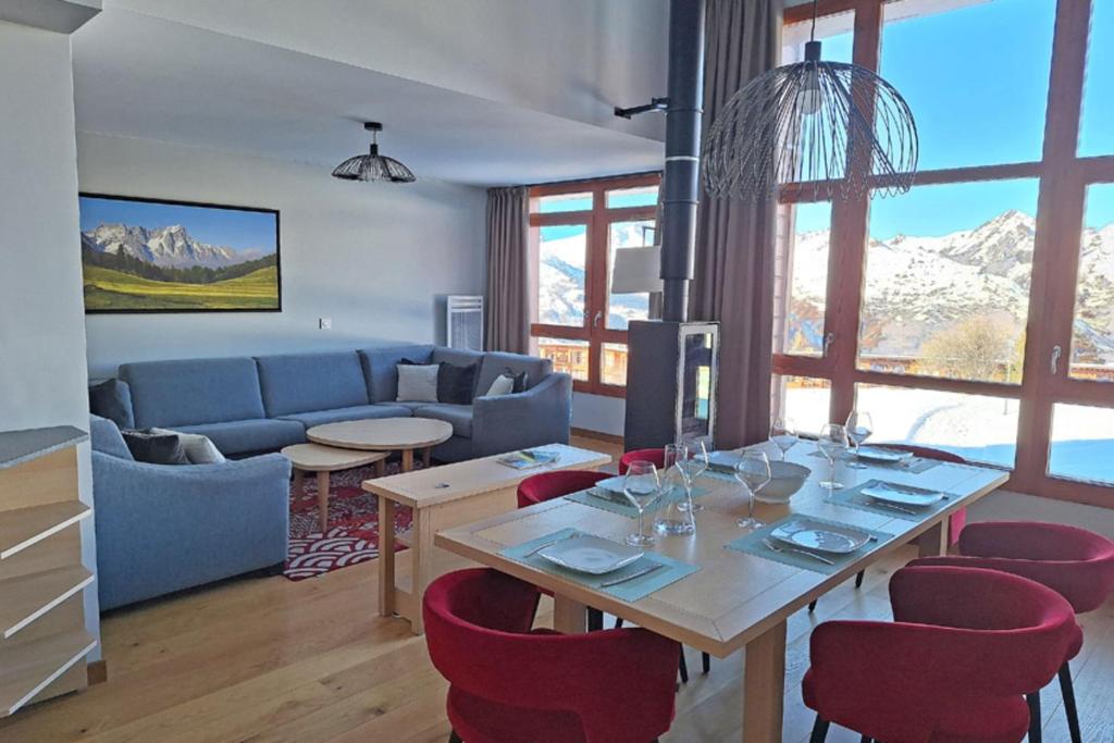 Séjour de l'appartement à Arc 1800 avec table dressée face aux sommets enneigés
