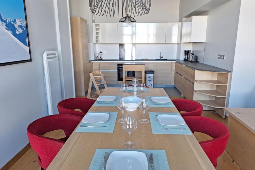 Grande table dressée pour huit personnes, ouverte sur la cuisine